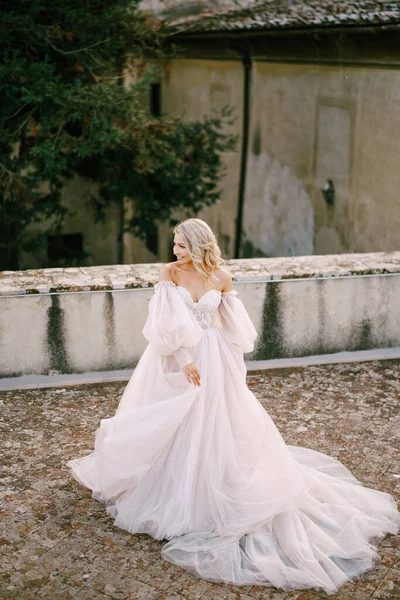 Pernikahan di sebuah vila anggur tua di Tuscany, Italia. Mempelai dalam gaun pengantin putih dengan bahu telanjang dan lengan. — Stok Foto