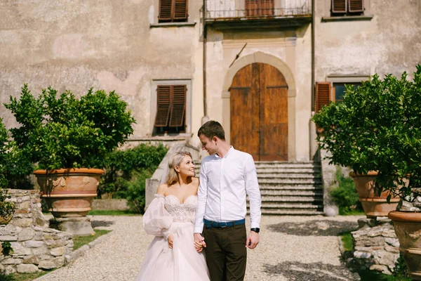 イタリアのフィレンツェで、古いヴィラワイナリーで結婚式。結婚式のカップルが庭を歩く。花嫁と新郎を愛する. — ストック写真