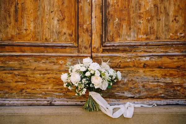 Buquê de noivas brancas em um fundo de madeira . — Fotografia de Stock