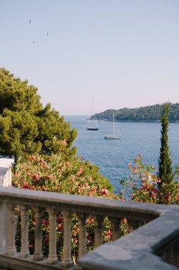 Lokrum, Hırvatistan 'ın Dubrovnik kenti yakınlarındaki Adriyatik Denizi' nde küçük bir ada. Yakınlardaki gemiler, yatlar ve tekneler üzerindeki eski bir otelin penceresinden manzara..