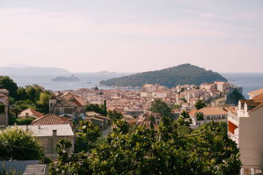 Lokrum adasının arka planındaki eski Dubrovnik şehri ve şafakta bir yolcu gemisi..