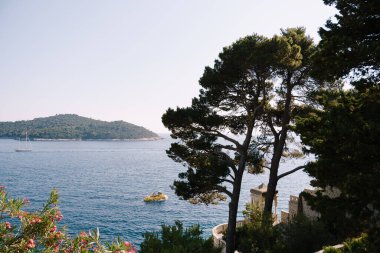 Lokrum, Hırvatistan 'ın Dubrovnik kenti yakınlarındaki Adriyatik Denizi' nde küçük bir ada. Yakınlardaki gemiler, yatlar ve tekneler üzerindeki eski bir otelin penceresinden manzara..