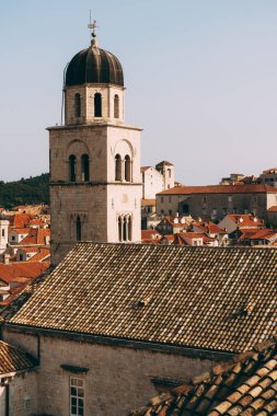 Dubrovnik 'teki Fransisken manastırının çan kulesi şehrin kiremitlerinin arka planına karşı..