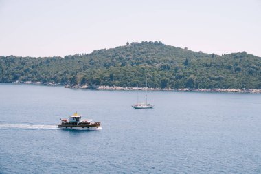 Lokrum, Hırvatistan 'ın Dubrovnik kenti yakınlarındaki Adriyatik Denizi' nde küçük bir ada. Turist gemileri adanın yanından geçiyor, kıyıya demir atmış bir yat..