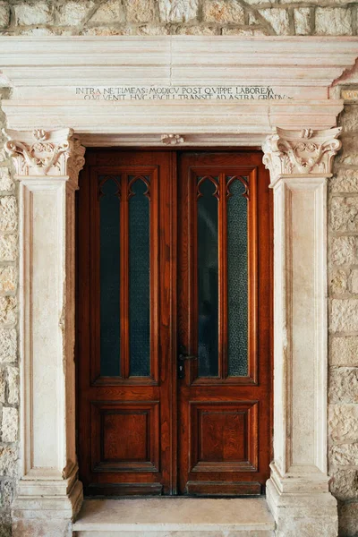 Red wooden door in a stone capital in the Dominican Monastery in Dubrovnik, Croatia. — Stock Photo, Image