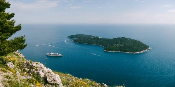 Lokrum é uma pequena ilha no Mar Adriático, perto de Dubrovnik, Croácia. Um pequeno navio de cruzeiro atracado perto da ilha. Vista do deck de observação da montanha acima de Dubrovnik . — Fotografia de Stock