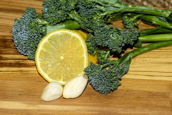 Organic baby broccoli with lemon slices and garlic cloves