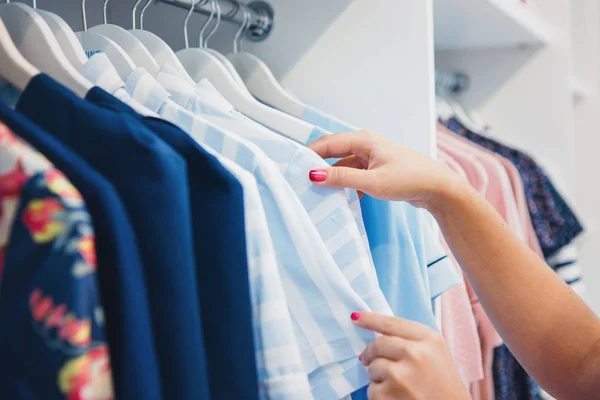 Mujer manos en perchas de ropa — Foto de Stock