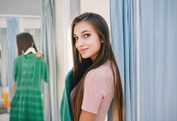 Jovem mulher verificando vestido — Fotografia de Stock