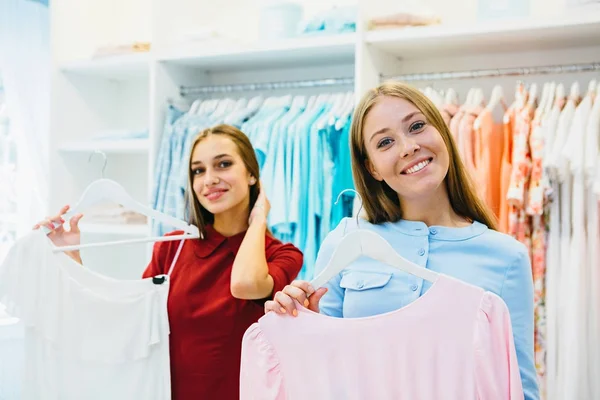Vrouwen winkelen en kiezen jurken — Stockfoto