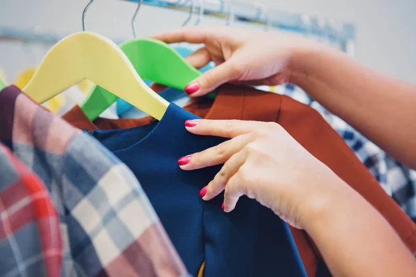 Woman hands on clothes hangers