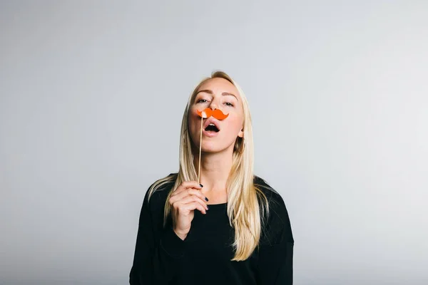 Mujer sostiene una cabina de fotos un bigote — Foto de Stock