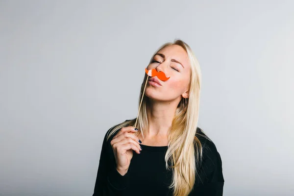 Woman holds a photo booth a mustache — Stock Photo, Image