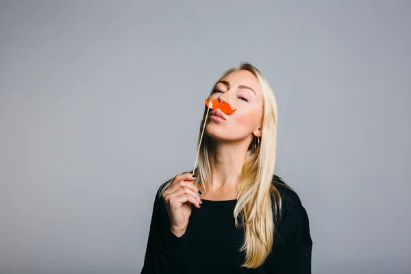 Woman holds a photo booth a mustache — Stock Photo, Image