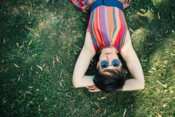 Femeie liying cu ochelari pe iarbă  . — Fotografie, imagine de stoc