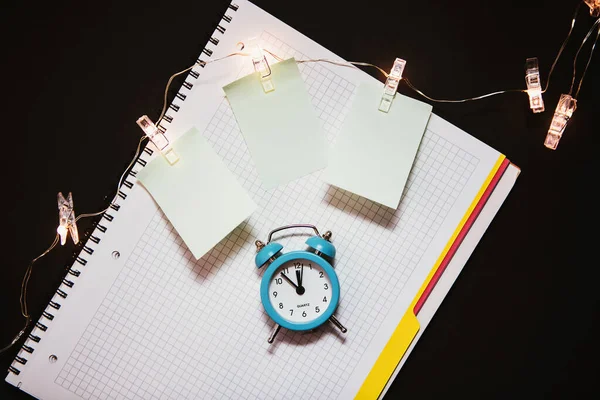Relógio de alarme azul, diário de notebook aberto limpo . — Fotografia de Stock