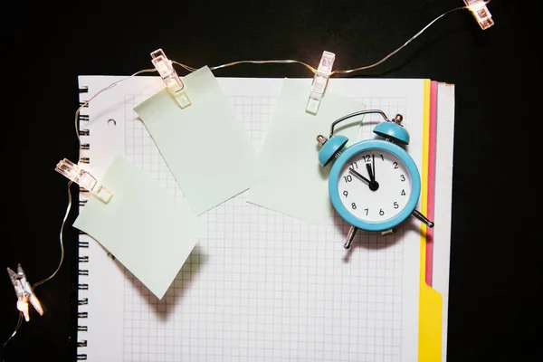 Relógio de alarme azul, diário de notebook aberto limpo . — Fotografia de Stock
