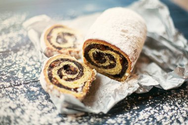 Ahşap arka planda haşhaş tohumu rulosu, yakın plan