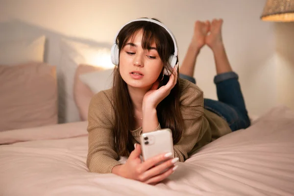 Het meisje met bluetooth koptelefoon en een telefoon — Stockfoto