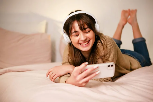 Vrouw Bed Met Bluetooth Hoofdtelefoon Telefoon — Stockfoto