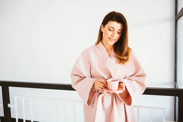 Beautiful girl in a bathrobe enjoying coffee at home. — ストック写真