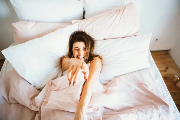 Mulher esticando na cama depois de acordar — Fotografia de Stock