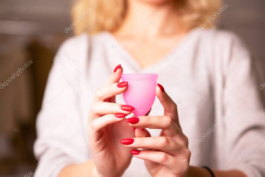 The girl holds a menstrual cup .
