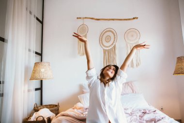 Kadın uyandıktan sonra yatakta geriniyor.