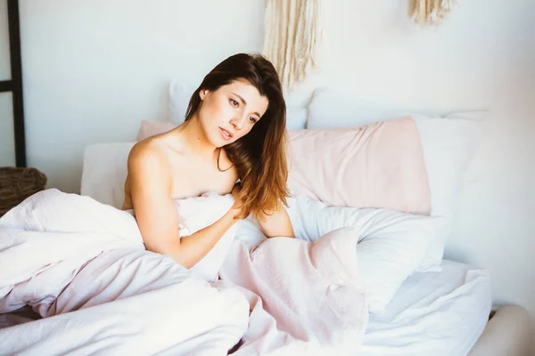 Jovem mulher relaxar e sorrir suavemente na cama . — Fotografia de Stock