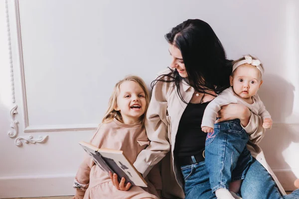 Mamma che legge ai bambini libro a casa . — Foto Stock