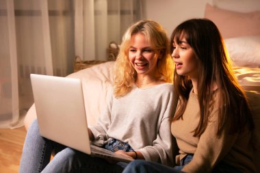 Genç kızlar, evde bilgisayar başında oturan öğrenciler.