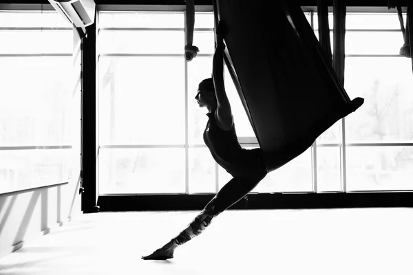 Silhouette of a beautiful young woman doing fly yoga — Stock Photo, Image