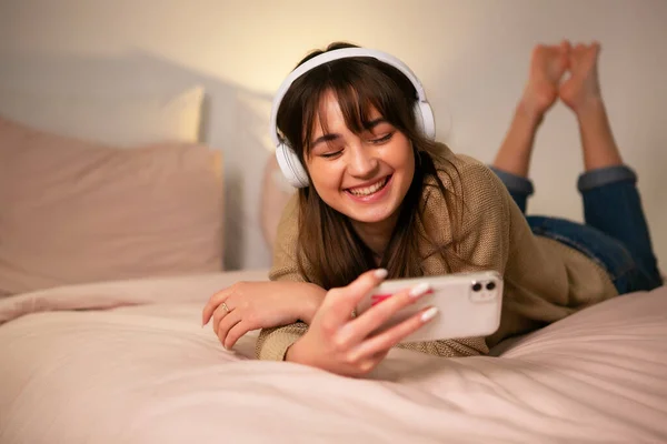 Dziewczyna ze słuchawkami bluetooth i telefonem. — Zdjęcie stockowe