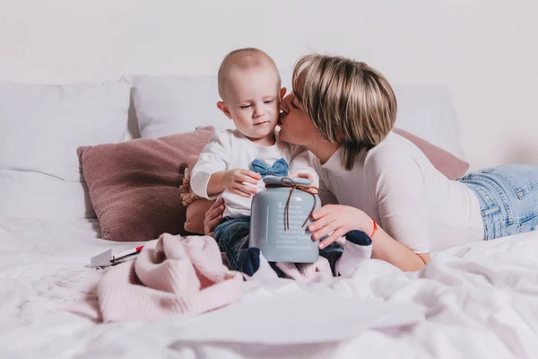 Giovane madre con il suo piccolo figlio di 1 anno che gioca con le matite nel letto — Foto Stock