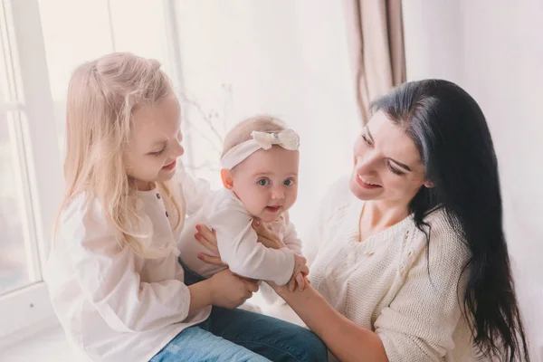 Ritratto di madre con due figlie in camera bianca vicino alla finestra . — Foto Stock