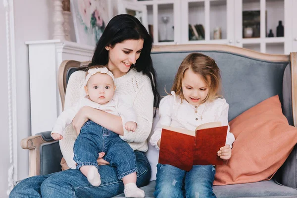 Mamma che legge ai bambini libro a casa . — Foto Stock