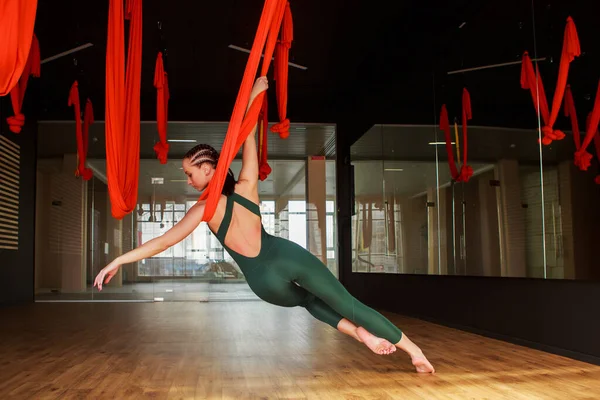 yoga instructor practicing fly yoga in the gym.