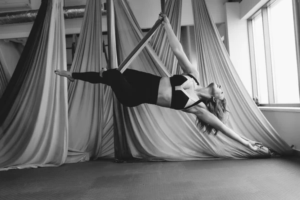 Vlieg yoga. Yoga op de hangmat. Mooi meisje gymnast doet vliegen yoga op groene doeken. — Stockfoto