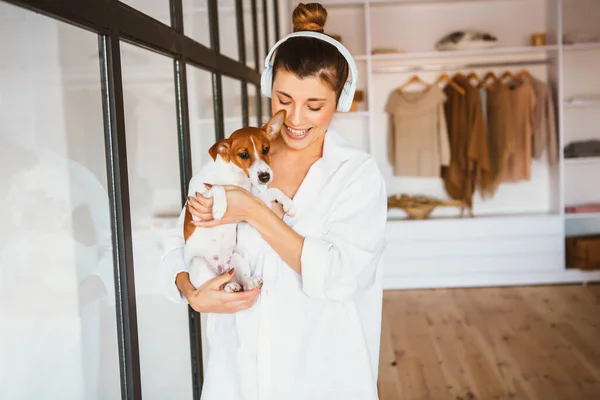 Sorrindo jovem mulher em camisa branca desfrutando de bom dia e posando com seu animal de estimação — Fotografia de Stock