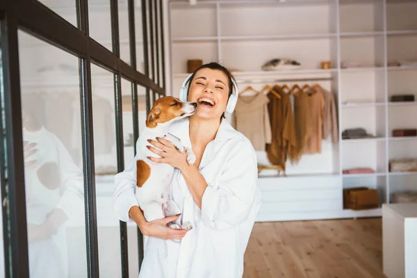Uśmiechnięta młoda kobieta w białej koszuli cieszy się dobrym dniem i pozuje ze swoim zwierzakiem — Zdjęcie stockowe