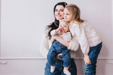 Anne ve kızlar oynuyor, öpüşüyor ve sarılıyorlar..