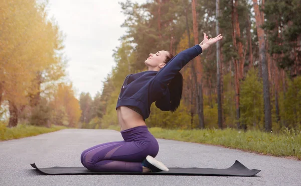 Die Frau Praktiziert Yoga Der Natur Mädchen Machen Übungen Freien lizenzfreie Stockfotos