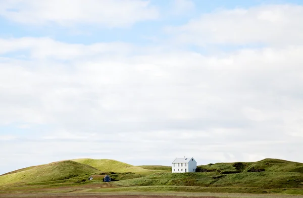 Schönes weißes Haus gegen bewölkten Himmel in Island. Stockbild