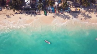 Karayipler 'de dalgalar, beyaz kumlar ve cennet gibi palmiye ağaçları olan bir tekne.