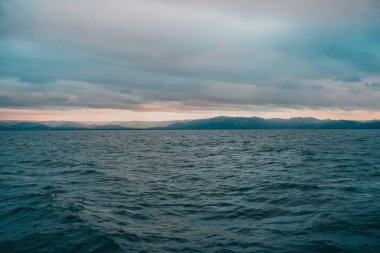 Suyun içindeki dağlar Bulutlu bir gün batımı