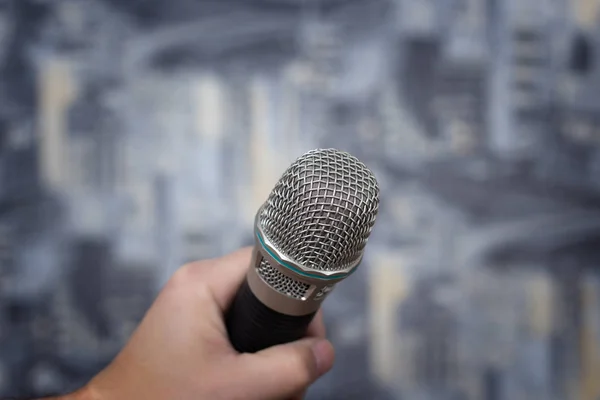 microphone in hand on blurred background