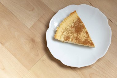 Yan tabakta bir dilim ev yapımı sütlü tart.