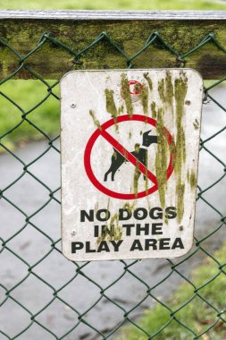 Parktaki çitlerin orada köpeklerin girmesine izin verilmeyen bir tabela var. 