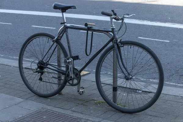 Une Vue Rapprochée Vélo Noir Verrouillé Sur Poteau Vélo Extérieur — Photo