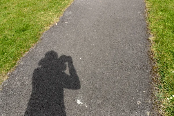 Parlak güneşin altında fotografileri alan birinin yakın görüntüsü.